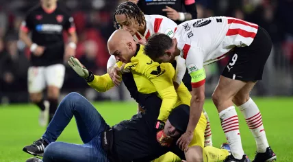 Supporter of PSV attacks Sevilla FC goalkeeper Marko Dmitrovic during the UEFA Europa league play-off match between PSV Eindhoven and Sevilla FC in the Phillips stadium on 23 february 2023 in Eindhoven, Netherlands.
