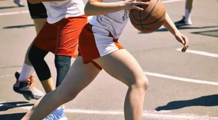 Teenage girls playing basketball