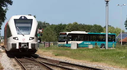 An Arriva bus waiting for an Arriva train to pass at station Lichtenvoorde-Groenlo