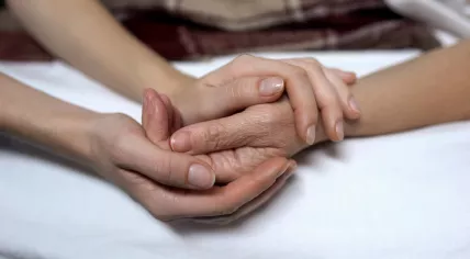 Woman cupping an elderly woman's hand