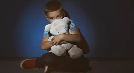 Scared boy with teddy bear. 