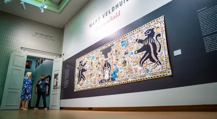Artist Mart Veldhuis in front of his tapestry, Eigen Schuld, in 2021