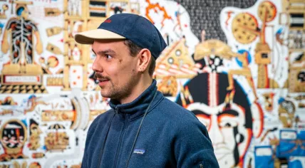 Artist Mart Veldhuis in front of his tapestry, Eigen Schuld, in 2021