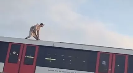 Man surfs on the roof of a moving subway in Amsterdam, 20 May 2023