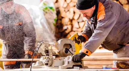 Carpenters using a circular saw in a workshop