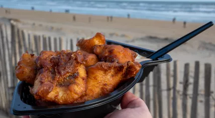 A disposable plastic container holding kibbeling, at the North Sea beach in the Netherlands.