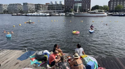 People enjoying the summer and sunshine at the dock in Amsterdam, 17 June 2023