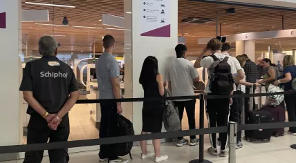 People waiting in line at border control at Schiphol Airport, 25 June 2023