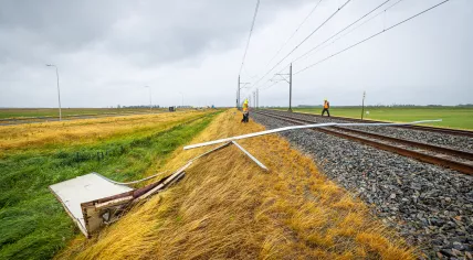 ProRail workers examine railroad track where part of the roof of a truck blew onto the tracks during Storm Poly. 5 July 2023