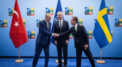 Turkish President Recep Tayyip Erdogan shaking hands with Swedish Prime Minister Ulf Kristersson in the presence of NATO Secretary General Jens Stoltenberg, 10 July 2023