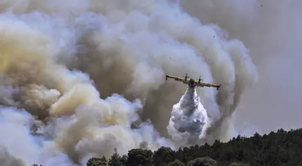 A Canadair firefighting aircraft sprays water during a fire in Dervenochoria, northwest of Athens, July 19, 2023.