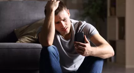 Unhappy man looking at his phone