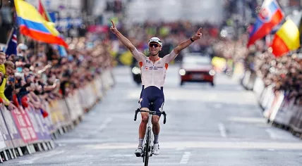 Mathieu van der Poel celebrates as he crosses the finish line to win the men's elite road race at the UCI World Championships in Glasgow. 6 August 2023