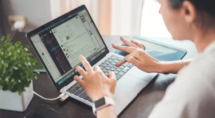A woman using Slack on her laptop during the work day