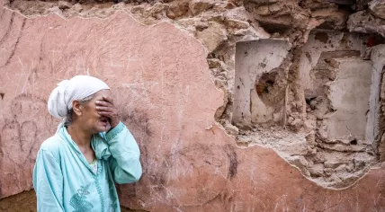 A woman reacts standing infront of her earthquake-damaged house in the old city in Marrakesh on September 9, 2023. 