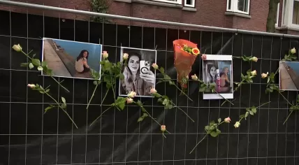 Photos of Romy, 14, and Marlous, 39, on privacy screens placed in front of their home after they were shot dead in Rotterdam on 29 September 2023