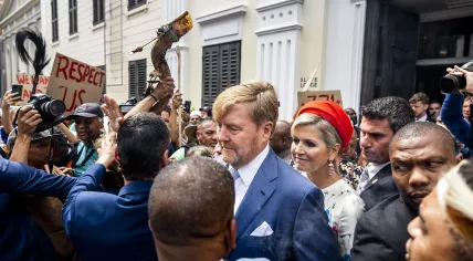 King Willem-Alexander and Queen Maxima walk through a crowd of protesters at the Iziko Slave Lodge museum in Cape Town during a state visit to South Africa, 20 October 2023