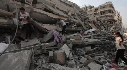 Palestinians inspect the ruins of Aklouk Tower destroyed in Israeli airstrikes in Gaza City on October 8, 2023.