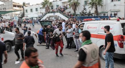 A medic carries an injured Palestinian child into Al-Shifa hospital in Gaza City following an Israeli airstrike on 11 October 2023.