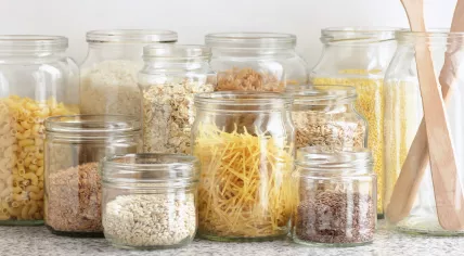 Variety of cereals, grains, pasta, seeds in glass jars