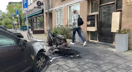 Aftermath of a fire on Derde Oosteparkstraat in Amsterdam on 18 October 2023. A motorcycle is almost completely burnt out and a car is damaged. 18 October 2023