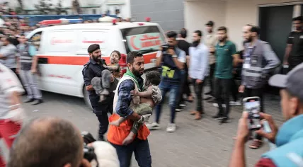 Medics transport injured Palestinian children into Al-Shifa hospital in Gaza City following an Israeli airstrike on 11 October 2023.