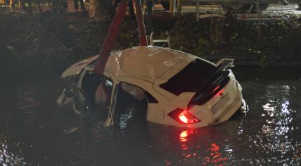  A car is towed out of the water in Delft after it fell into it for unknown reasons. 