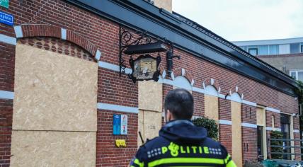 Police officer in front of a building on Koninginnestraat in Vlaardingen after an explosion. 