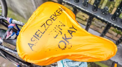 A cover on a bicycle in Amsterdam says, "Asylum seekers are okay". February 2014
