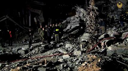 Officials and rescue workers at the site of a collapsed building following a missile strike in Erbil, Iraq. 15 January 2024