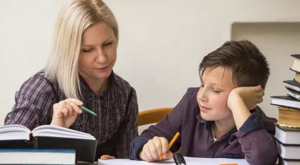 Boy doing school work with a tutor