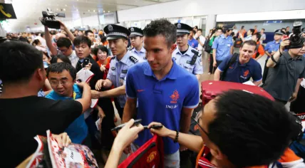 Dutch footballer Robin van Persie, center, is surrounded by Chinese fans at the Beijing Capital International Airport in Beijing, China.