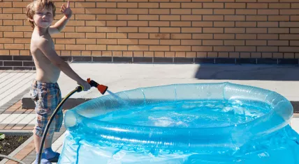 Boy filling an inflatable pool