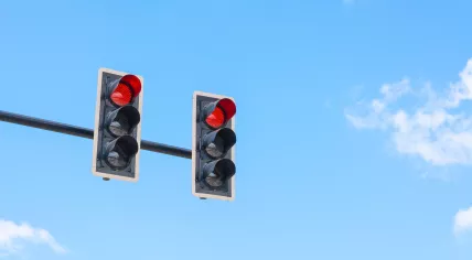 A traffic light in front of a blue sky.