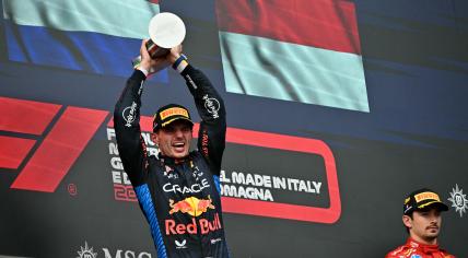 Race winner Red Bull Racing's Dutch driver Max Verstappen holds his trophy as third-placed Ferrari's Monegasque driver Charles Leclerc (R) stands on the podium of the Emilia Romagna Formula One Grand Prix at the Autodromo Enzo e Dino Ferrari race track in Imola on May 18, 2024. 