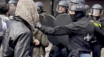 The moment a police officer charged into a pro-Palestinian demonstration in Amsterdam to grab one young man in a yellow hat, as the other officers used shields, batons and dogs to push the crowd back. 9 May 2024