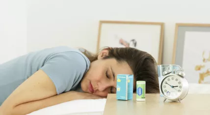 Woman sleeping with benzodiazepine sleeping pills on her bedside table