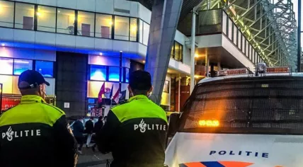 Police watching PSV fans leaving the celebration of their team's 25th Eredivisie title, 6 May 2024