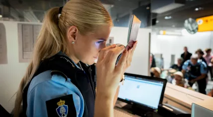 A Koninklijke Marechaussee officer checking a passport