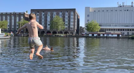 A boy jumps into the water from a pier in Amsterdam on the hottest day of the year to date. 27 June 2024