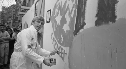 Jan Cremer paints a fence on the Nieuwendijk in Amsterdam