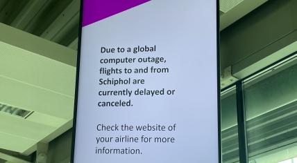 A sign at Schiphol Airport informing travelers that a global Windows outage has delayed or canceled all flights at the airport, 19 July 2024