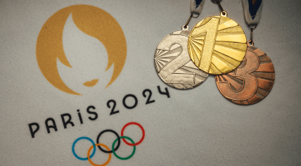 Gold silver and bronze medal on white blanket with official logo of Summer olympic game in Paris 2024