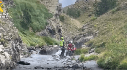 Spanish rescue workers helping a hiker in the Pyrenees mountains in the Huesca province