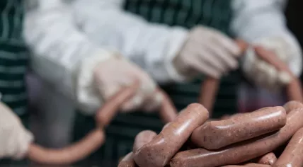 Butchers processing sausages