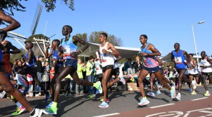 Runners past the De Gooyer windmill on their way from Amsterdam Oost into the city center during the 2017 Amsterdam Marathon. 15 October 2017