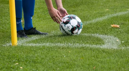 A football player sets up to take a corner kick in 2021