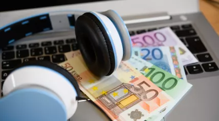 Computer keyboard with headphones and euro bank notes