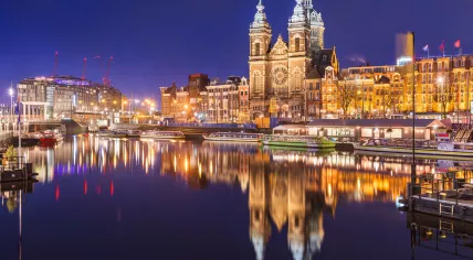 Tour boats moored near the Basilica of St. Nicholas in Amsterdam. 18 March 2021