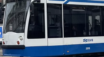 A tram heading west through the center of Amsterdam in 2024